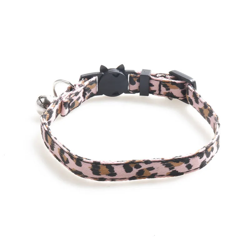 Brown cloth cat collar with attached bell on a white background