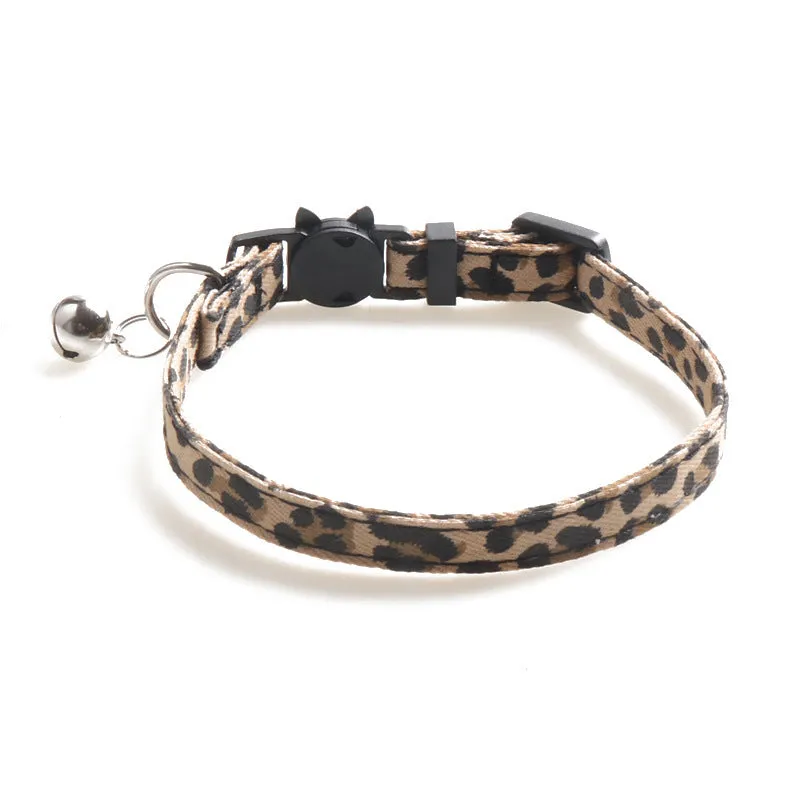 Brown cloth cat collar with attached bell on a white background