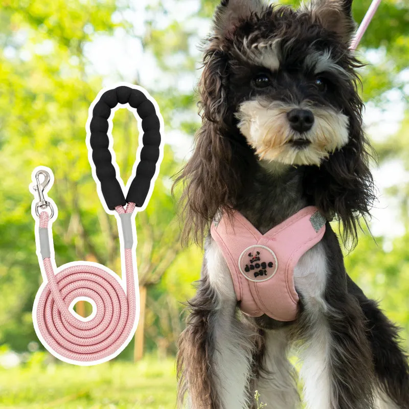 Pink polyester dog vest with an attached hand holding rope laid flat