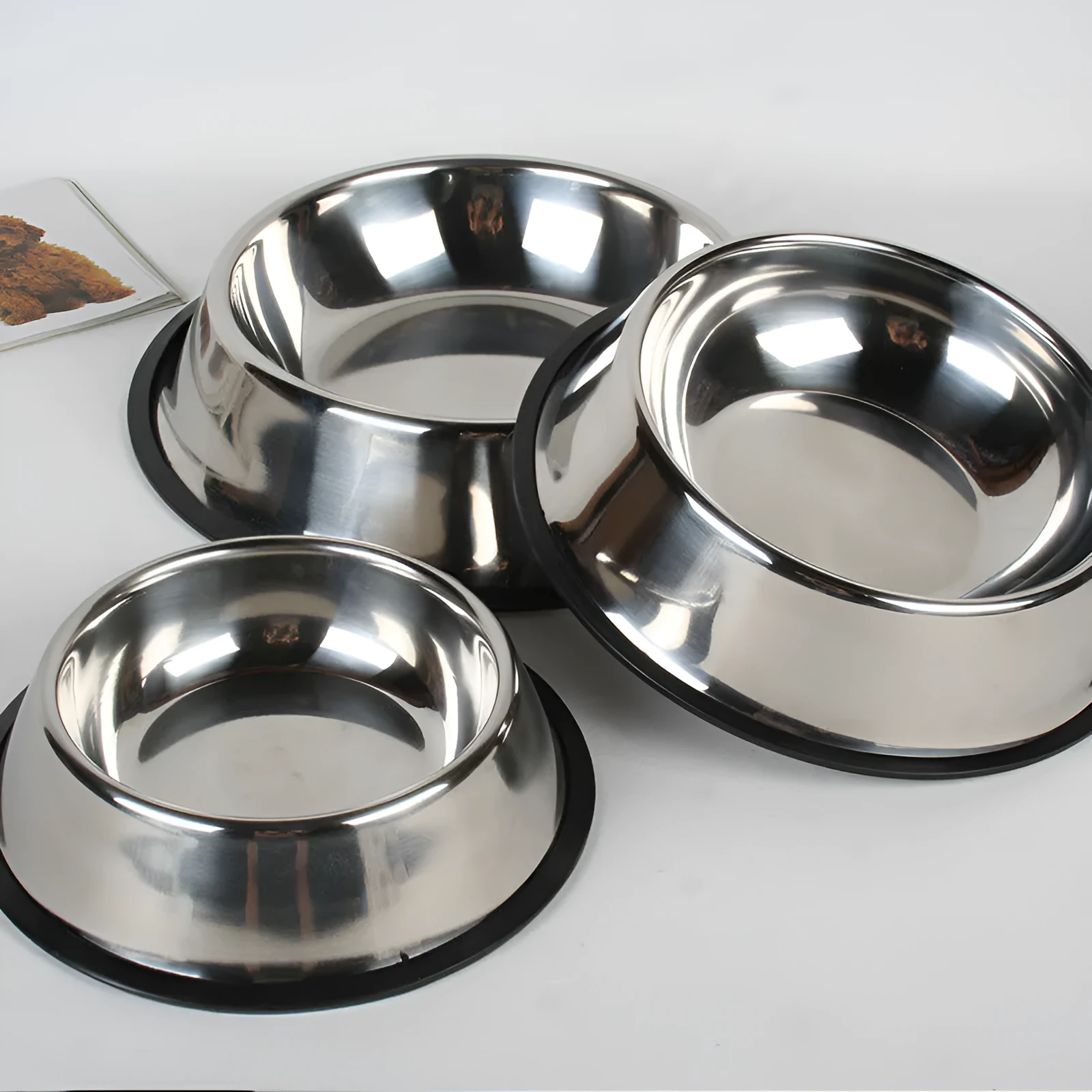 Classic stainless steel pet bowl with non-slip rubber base on a tiled floor