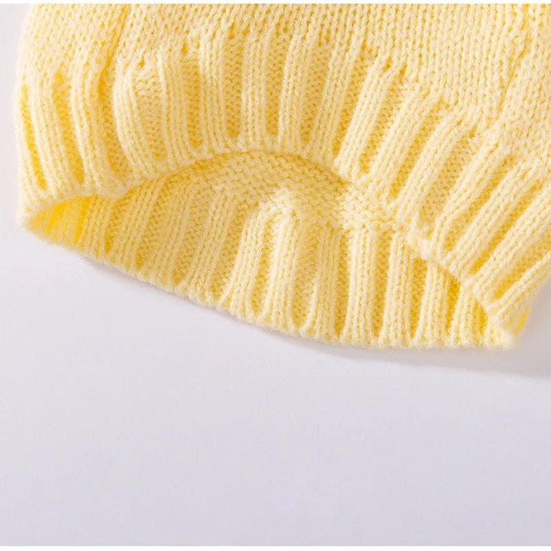 Yellow knitted dog sweater with star pattern and turtleneck on small breed puppy