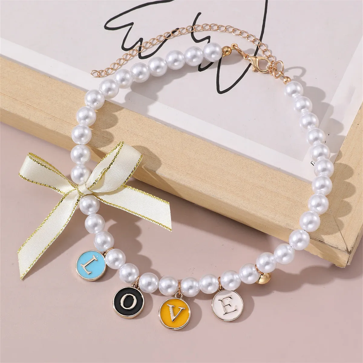 Cartoon pattern monochrome pet pendant necklace on a white background – pearl-like material, black colour option