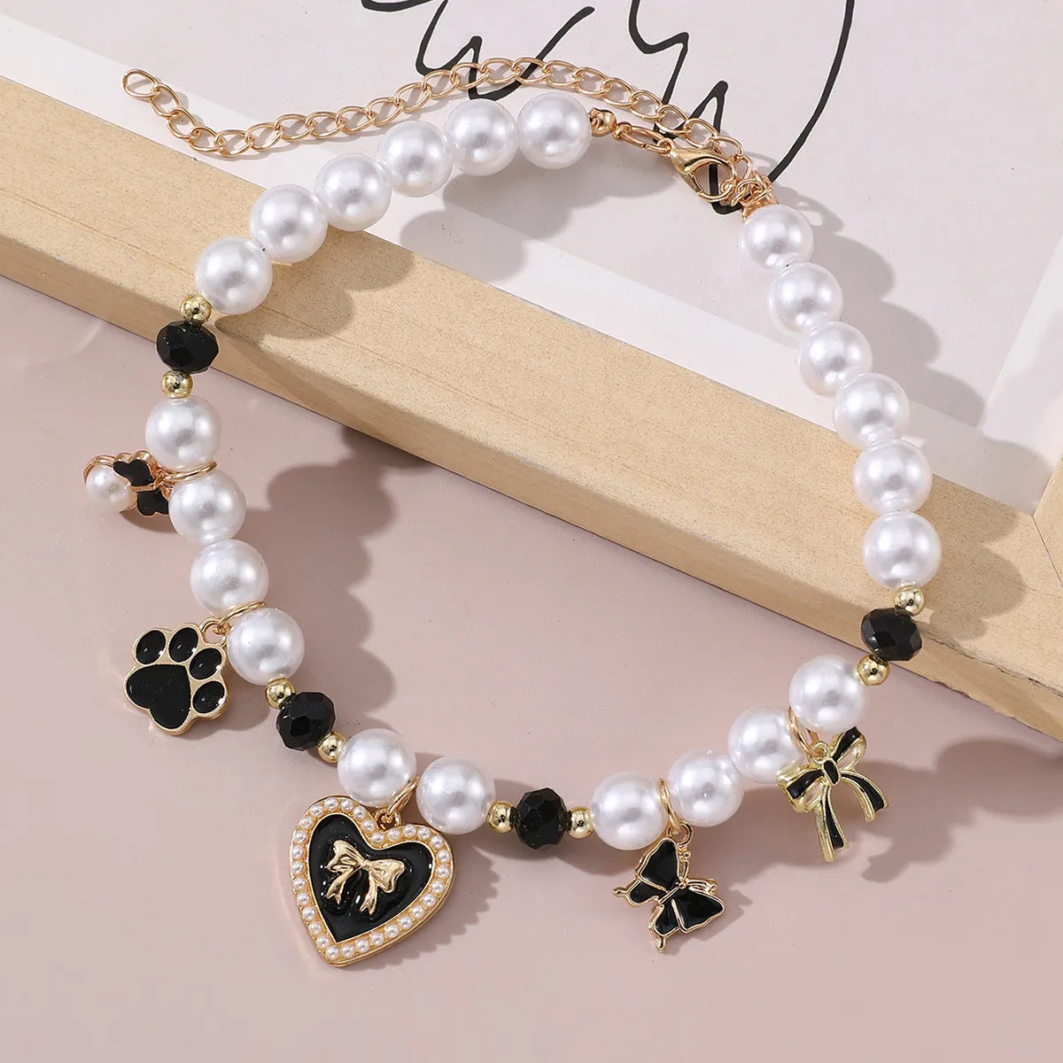 Cartoon pattern monochrome pet pendant necklace on a white background – pearl-like material, black colour option