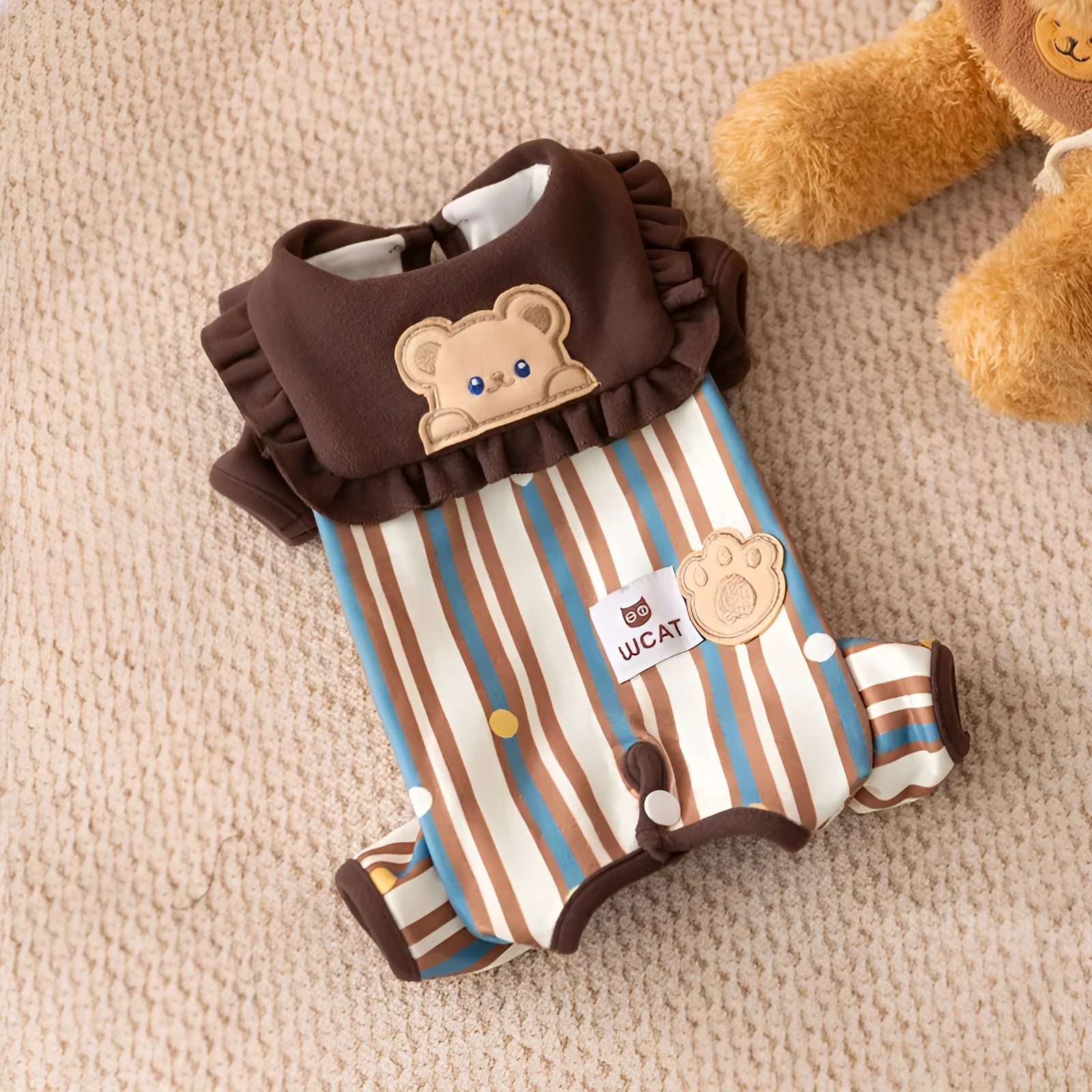 Brown small dog onesie with bear-embroidered ruffled collar, striped blue and brown body, and paw print patch