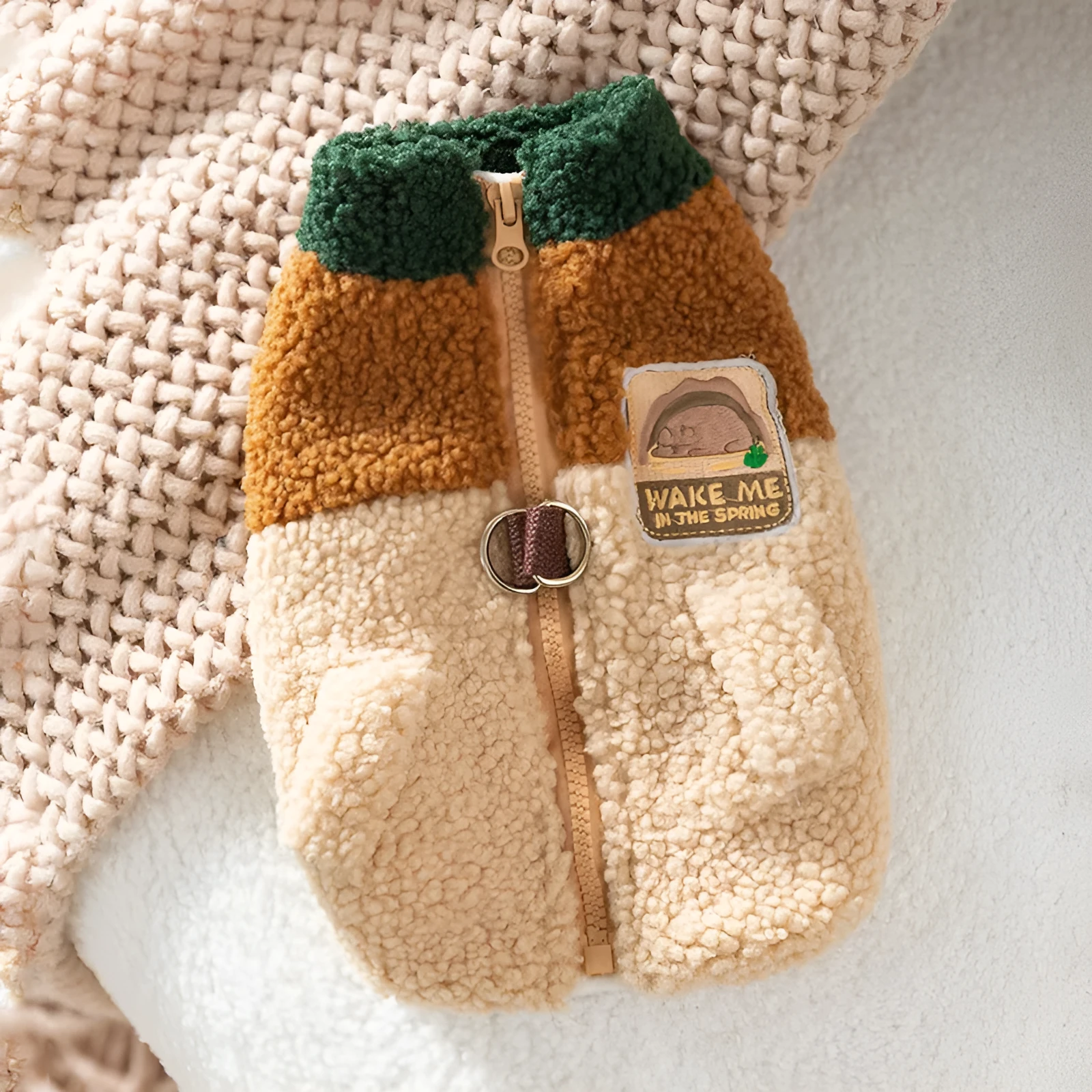 Colour-block pet fleece jacket with squirrel patch, leash ring, and pockets in green, brown, and beige on a small dog.