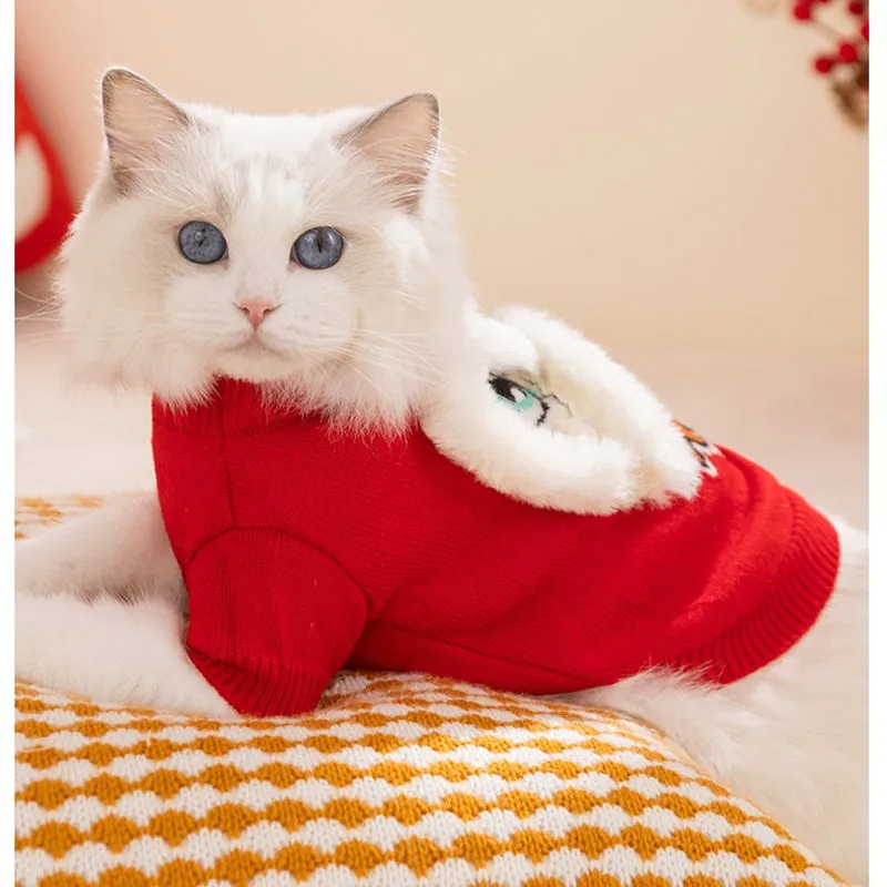 Red knitted lion dance pet sweater with 3D plush face details and colourful embroidery on a cat