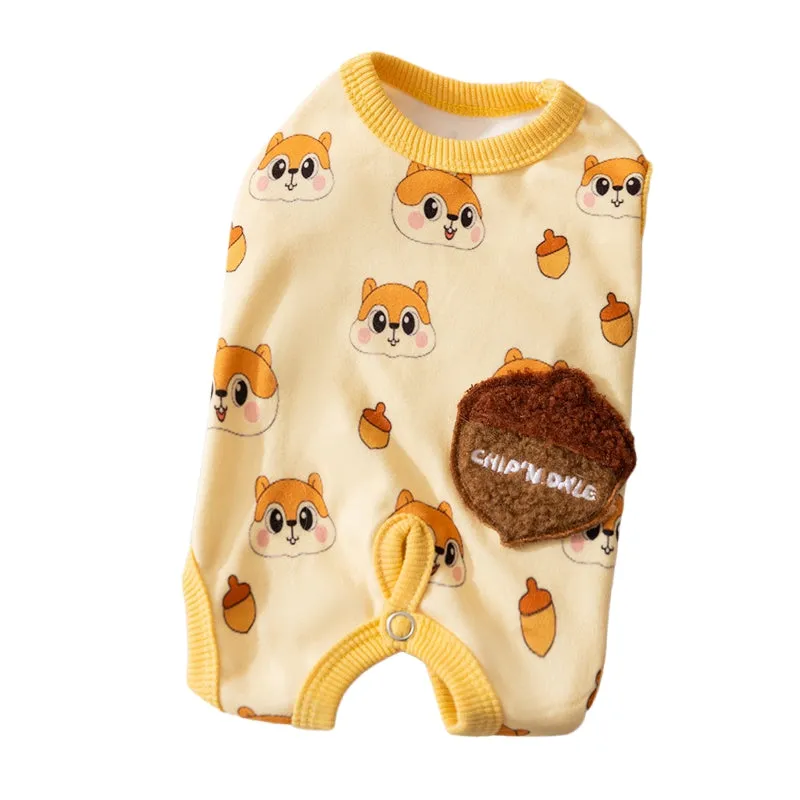 Small dog wearing Chip 'n' Dale themed cream onesie with yellow trim and embroidered acorn pocket