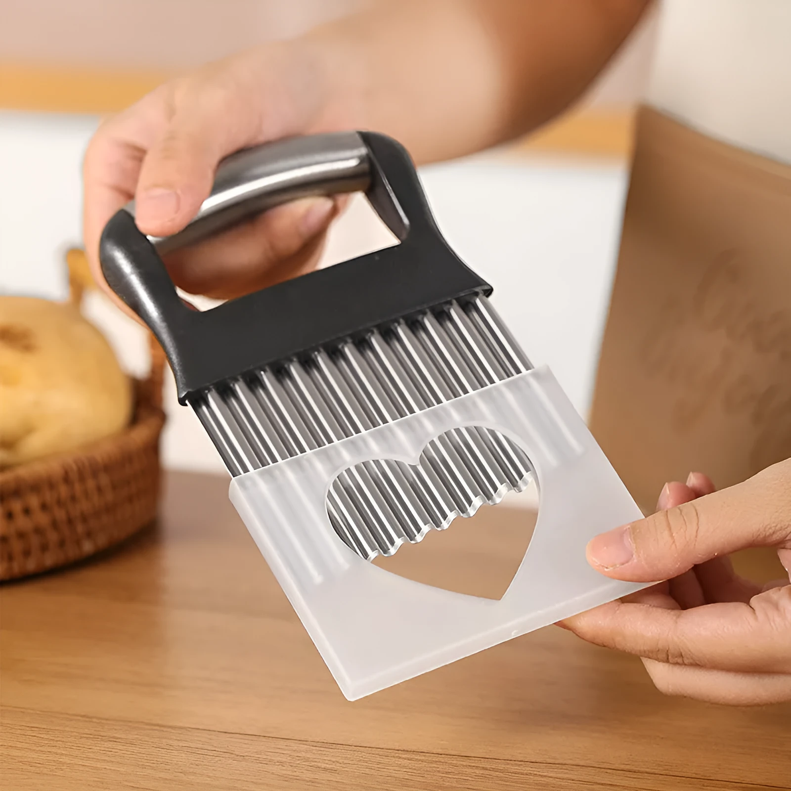 Stainless steel potato wave knife for making crinkle-cut chips on a kitchen worktop.