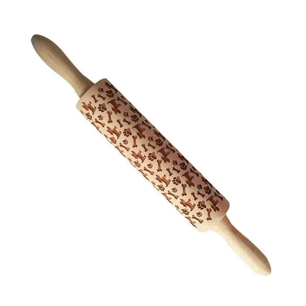 Wooden rolling pin with embossed Christmas patterns, 45cm long, on a kitchen worktop.