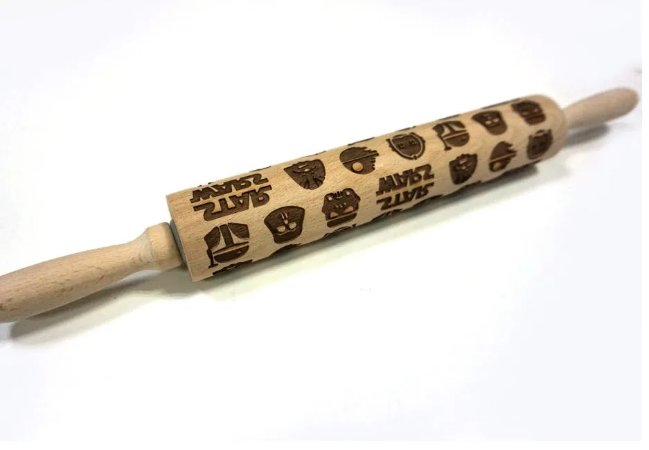 Wooden rolling pin with embossed Christmas patterns, 45cm long, on a kitchen worktop.