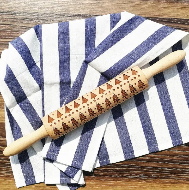 Wooden rolling pin with embossed Christmas patterns, 45cm long, on a kitchen worktop.