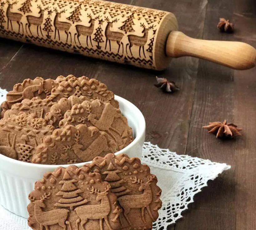 Wooden rolling pin with embossed Christmas patterns, 45cm long, on a kitchen worktop.