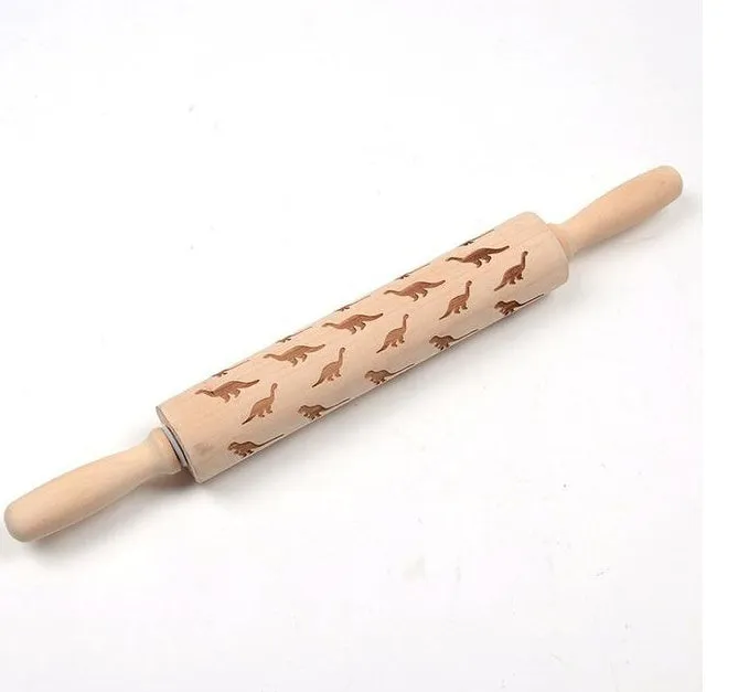 Wooden rolling pin with embossed Christmas patterns, 45cm long, on a kitchen worktop.