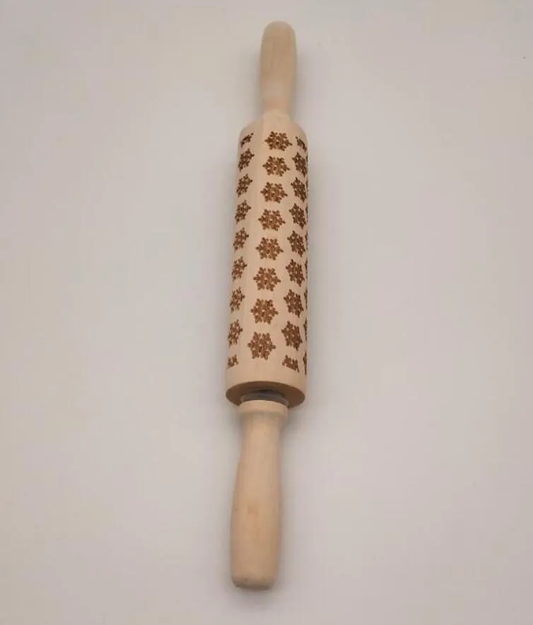 Wooden rolling pin with embossed Christmas patterns, 45cm long, on a kitchen worktop.