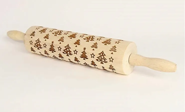 Wooden rolling pin with embossed Christmas patterns, 45cm long, on a kitchen worktop.