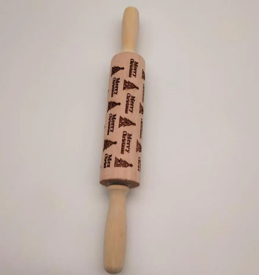 Wooden rolling pin with embossed Christmas patterns, 45cm long, on a kitchen worktop.