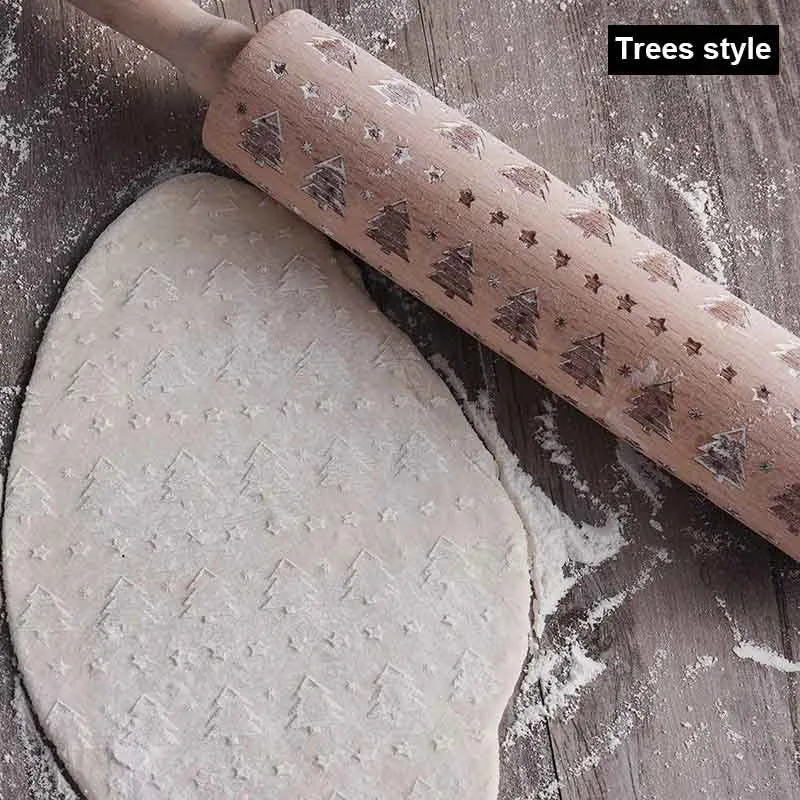 Wooden rolling pin with embossed Christmas patterns, 45cm long, on a kitchen worktop.