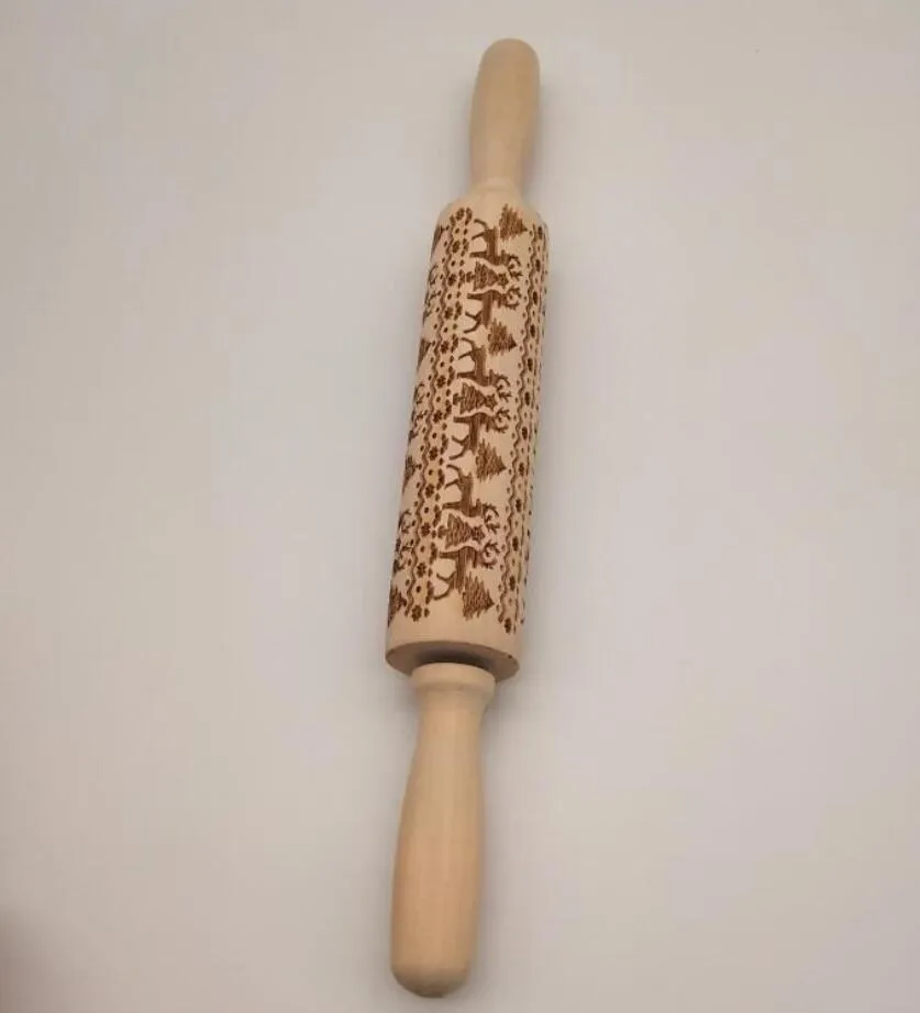 Wooden rolling pin with embossed Christmas patterns, 45cm long, on a kitchen worktop.