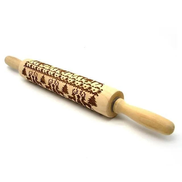Wooden rolling pin with embossed Christmas patterns, 45cm long, on a kitchen worktop.