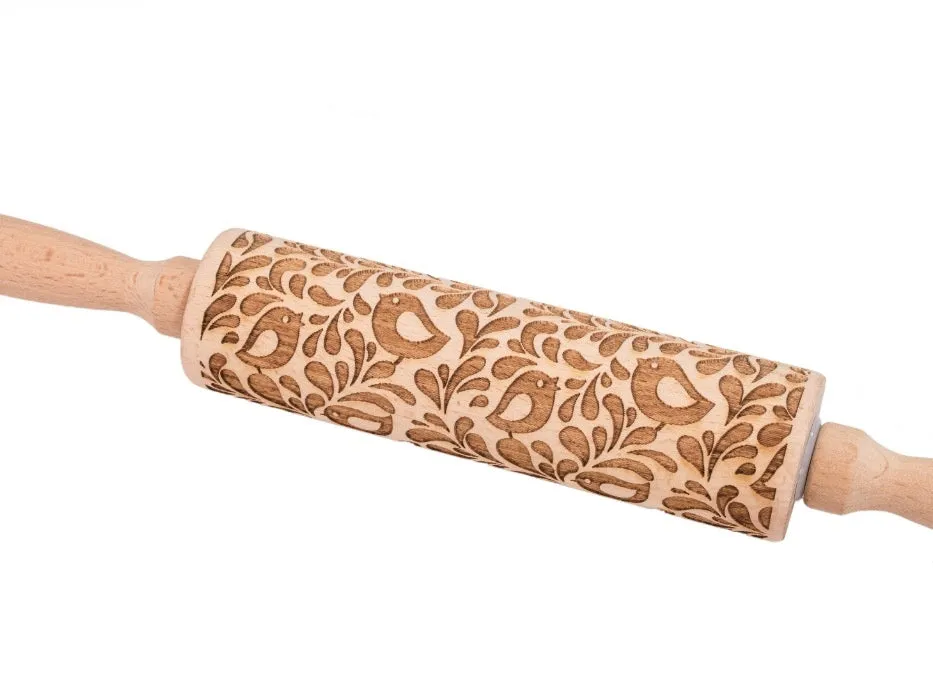 Wooden rolling pin with embossed Christmas patterns, 45cm long, on a kitchen worktop.