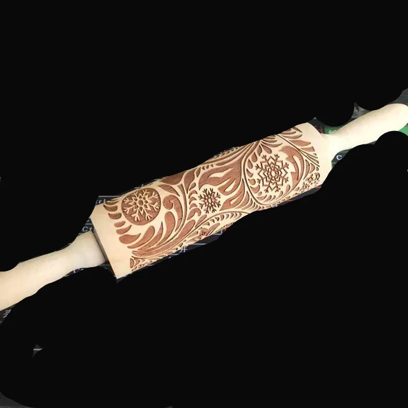 Wooden rolling pin with embossed Christmas patterns, 45cm long, on a kitchen worktop.