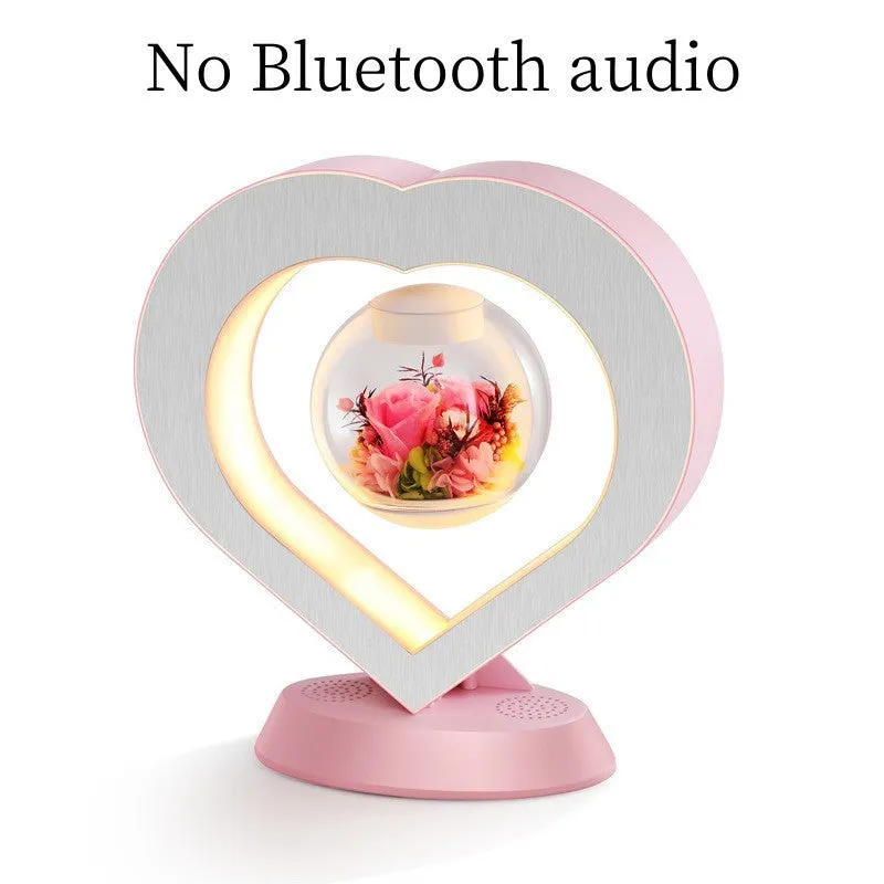 Pink floating heart LED levitation lamp with eternal flower on triangular base.