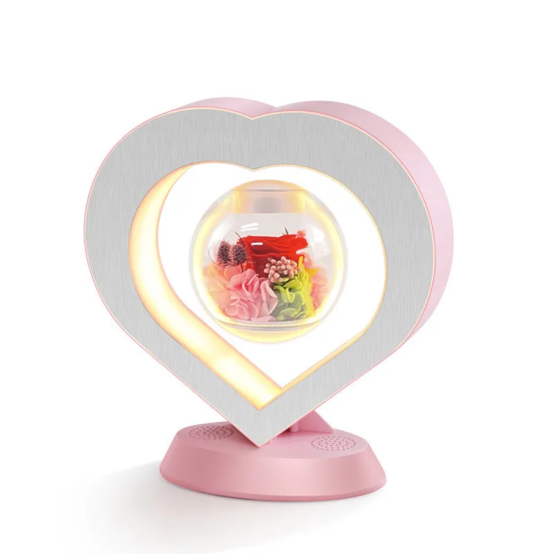 Pink floating heart LED levitation lamp with eternal flower on triangular base.