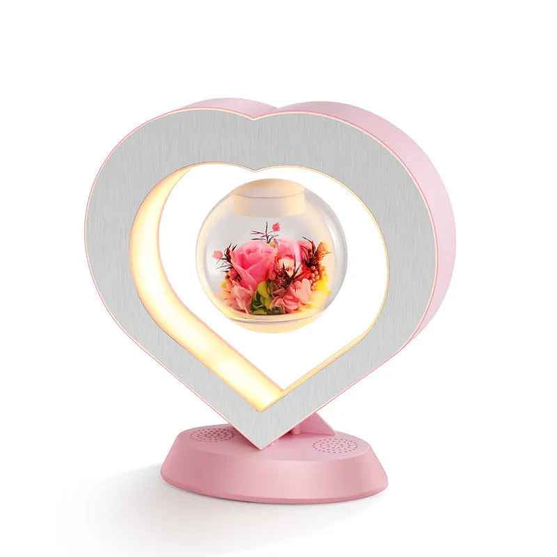 Pink floating heart LED levitation lamp with eternal flower on triangular base.