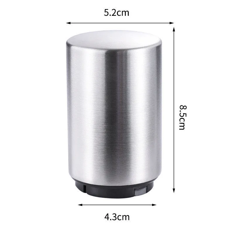 Stainless steel automatic bottle opener on a table, showing its compact size and press-down design.