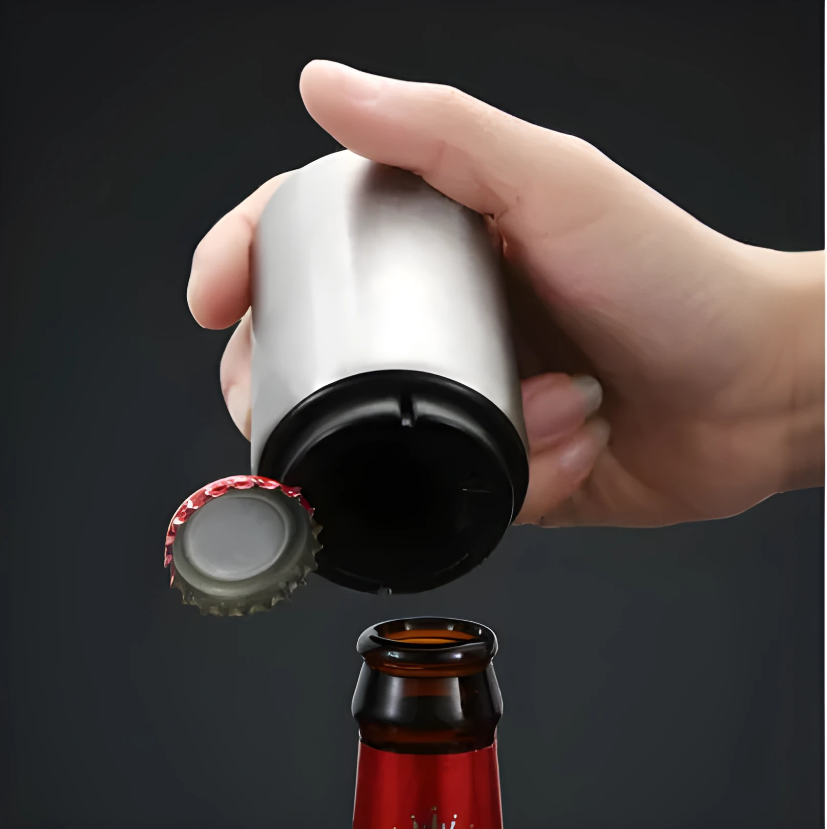 Stainless steel automatic bottle opener on a table, showing its compact size and press-down design.