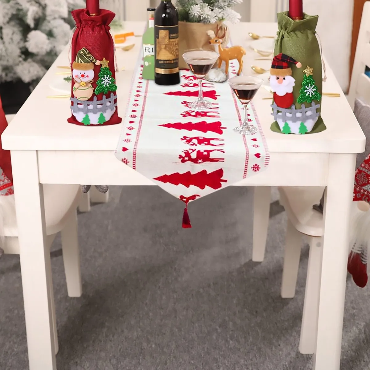 Red, white, and green Christmas table runner with elk and snowman print on a wooden dining table.