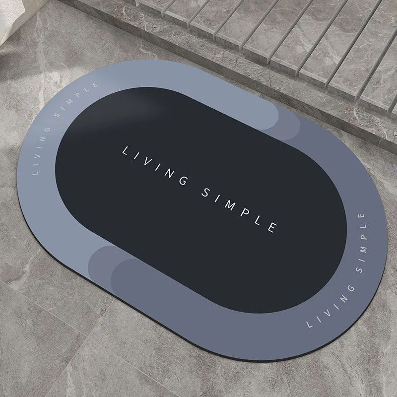 Oval grey polyester door mat with textured rubber non-slip backing on a wooden floor.