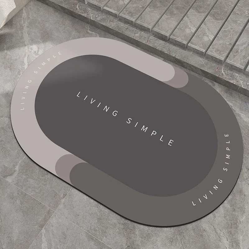 Oval grey polyester door mat with textured rubber non-slip backing on a wooden floor.
