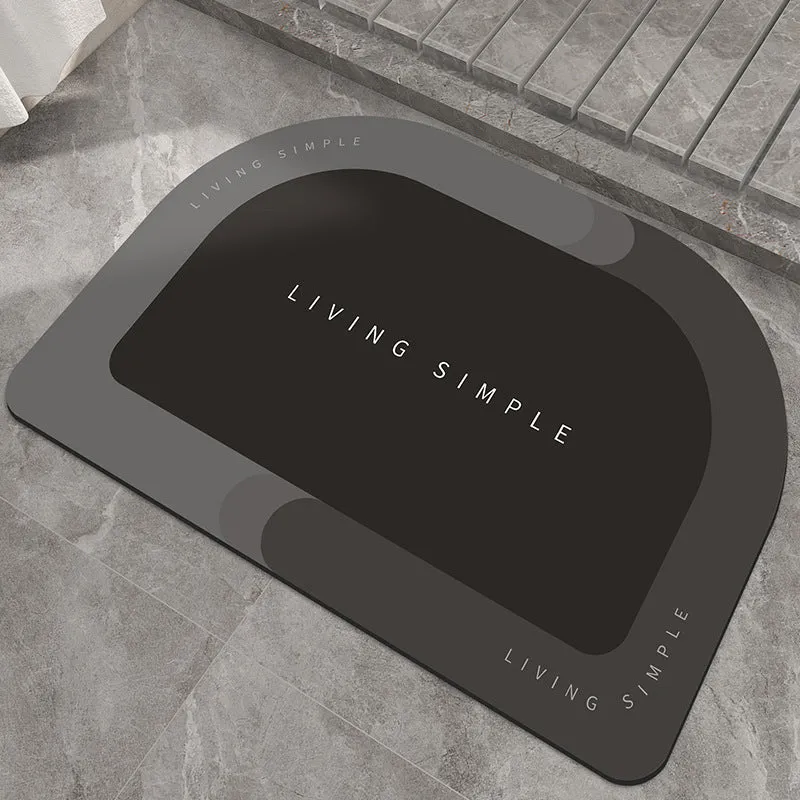 Oval grey polyester door mat with textured rubber non-slip backing on a wooden floor.