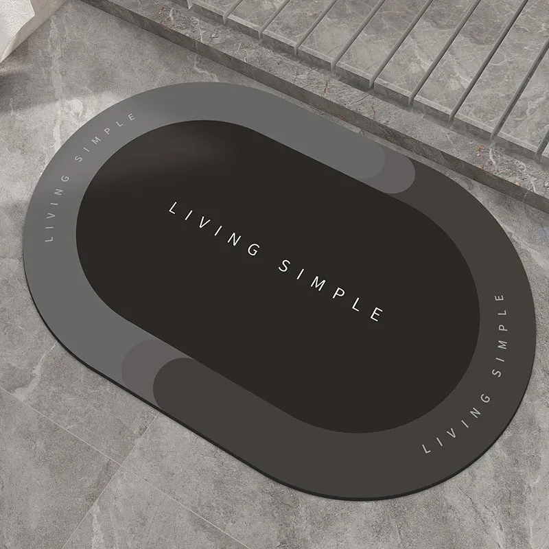 Oval grey polyester door mat with textured rubber non-slip backing on a wooden floor.