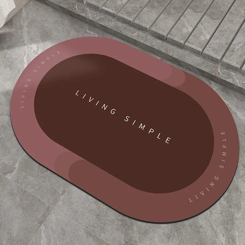 Oval grey polyester door mat with textured rubber non-slip backing on a wooden floor.