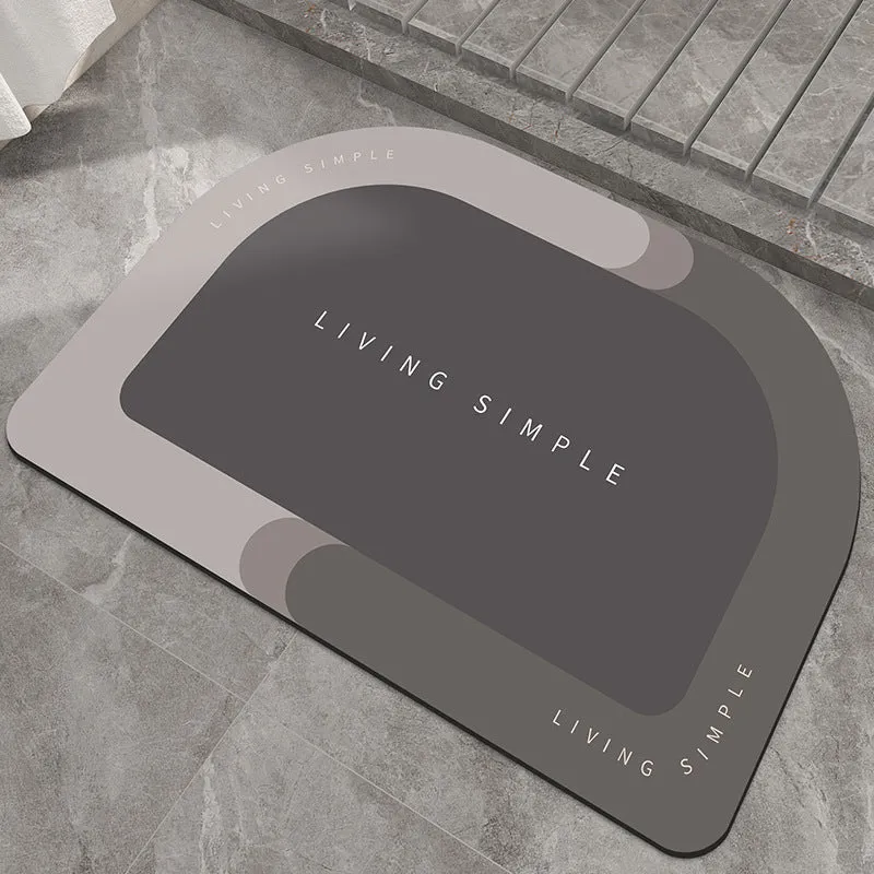 Oval grey polyester door mat with textured rubber non-slip backing on a wooden floor.