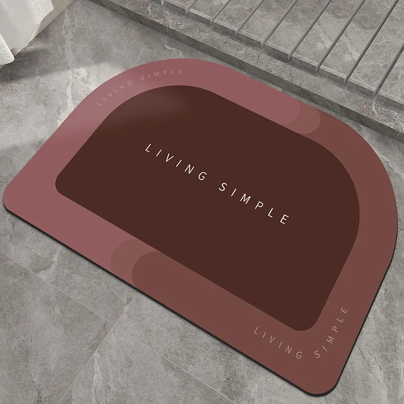 Oval grey polyester door mat with textured rubber non-slip backing on a wooden floor.