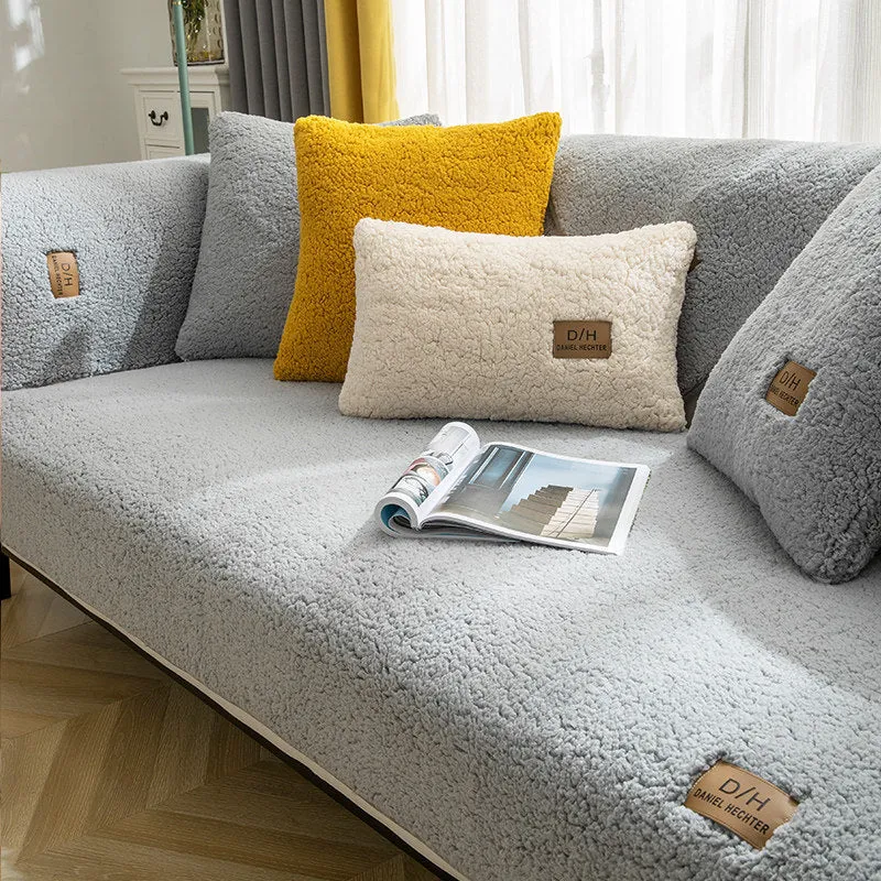 Beige plush sofa cover with anti-slip backing draped over a living room sofa cushion.