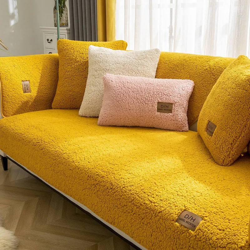 Beige plush sofa cover with anti-slip backing draped over a living room sofa cushion.
