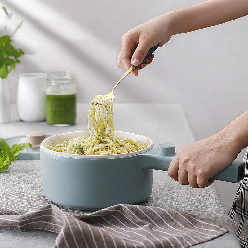 White and green multi-function electric cooking pot with temperature control dial, shown with a UK plug converter.