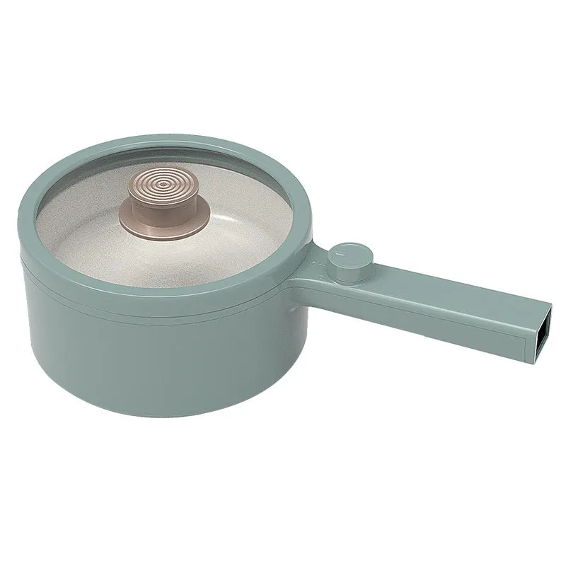 White and green multi-function electric cooking pot with temperature control dial, shown with a UK plug converter.