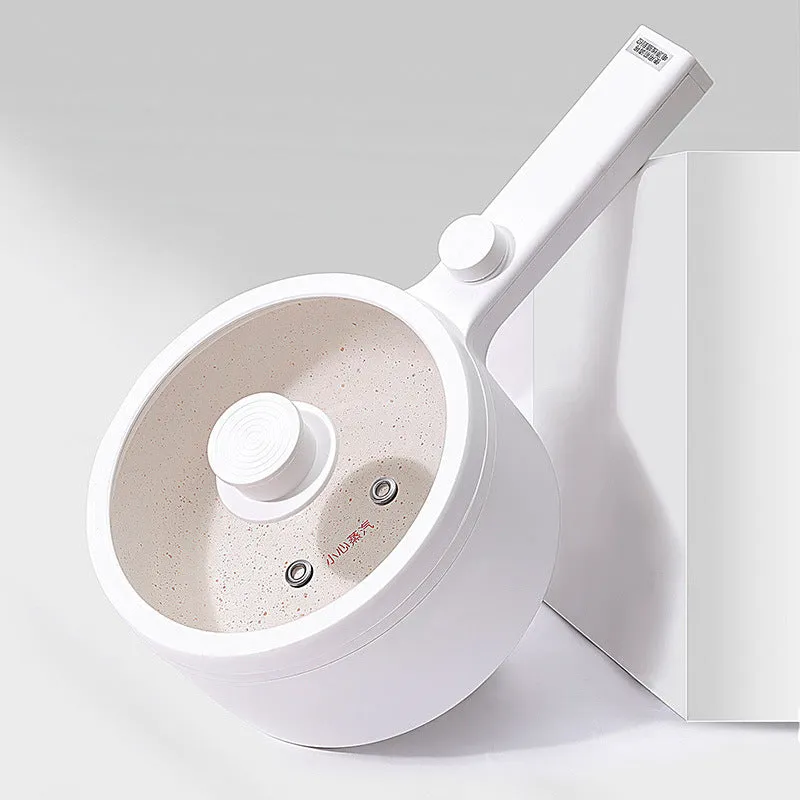 White and green multi-function electric cooking pot with temperature control dial, shown with a UK plug converter.