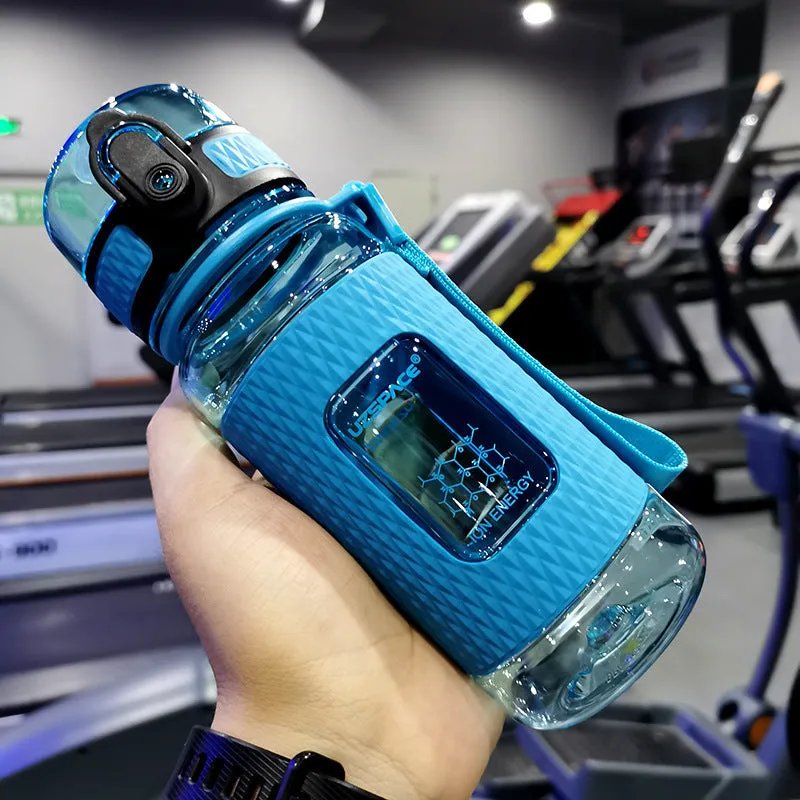 Blue portable sport water bottle with black lid on a gym bag.