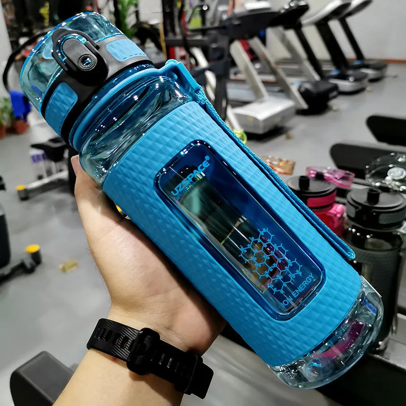 Blue portable sport water bottle with black lid on a gym bag.
