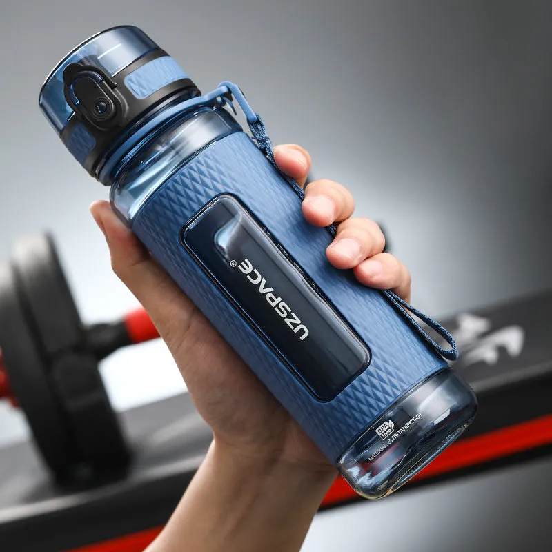 Blue portable sport water bottle with black lid on a gym bag.