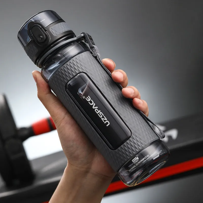 Blue portable sport water bottle with black lid on a gym bag.