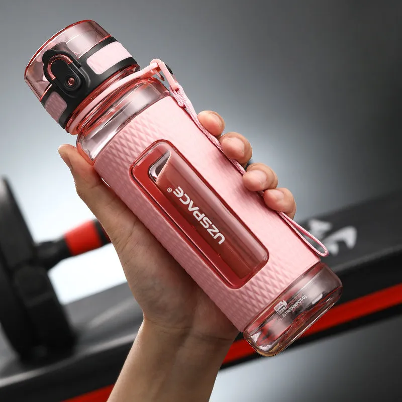 Blue portable sport water bottle with black lid on a gym bag.