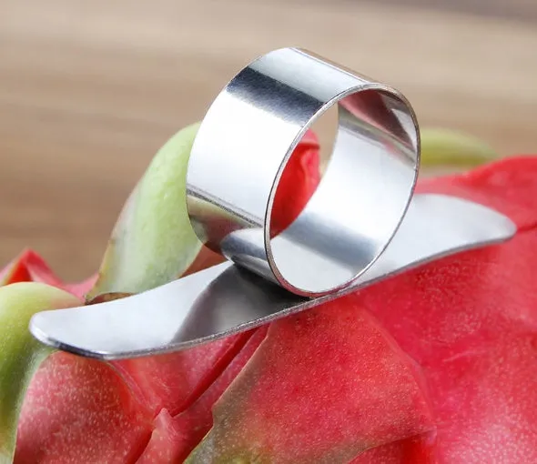 Silver stainless steel citrus fruit peeler with a ring-shaped handle on a kitchen surface.