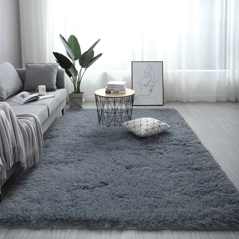 Nordic style rectangular plush carpet in a light colour on a wooden floor, showing fluffy texture.